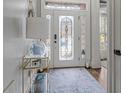 Inviting foyer with stained glass front door, neutral walls and blue patterned rug at 1525 Camden Cove Dr, Cumming, GA 30040