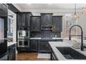 A gourmet kitchen featuring stainless steel appliances, dark cabinetry, and a modern backsplash at 1525 Camden Cove Dr, Cumming, GA 30040