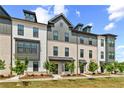 Stylish townhomes displaying brick and siding exteriors, accented by dormer windows and green lawns at 525 Rubato Knl, Mcdonough, GA 30253