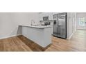 Modern kitchen featuring stainless steel appliances, white cabinets, granite countertops, and hardwood floors at 3181 Meadowstone Sw Ln, Atlanta, GA 30331