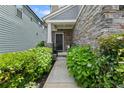 Inviting entryway featuring a stone facade, a black front door and lush landscaping at 3255 Morgan Rd, Buford, GA 30519