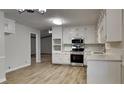 Bright kitchen featuring white cabinets, stainless steel appliances, and vinyl floors at 3284 Salem Se Ln, Conyers, GA 30013