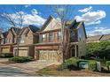 Side view of townhome showcasing brick and siding, complemented by manicured landscaping at 5711 Keys Way, Lithonia, GA 30058