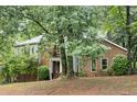 Two-story home with brick and stucco exterior shaded by mature trees at 175 River Run, Roswell, GA 30075