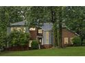 Beautifully landscaped front yard featuring lush grass, mature trees, and a charming two-story home at 175 River Run, Roswell, GA 30075