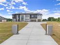 Long concrete driveway leading up to a modern two-story home with three-car garage at 2021 Jones Phillips Rd, Dacula, GA 30019