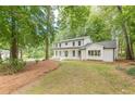 Charming two-story home with a front lawn and a white brick exterior surrounded by lush greenery at 418 Mockingbird, Smyrna, GA 30082