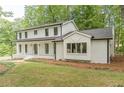 Striking two-story home showcasing a blend of white brick and siding, complemented by dark trim and a manicured lawn at 418 Mockingbird, Smyrna, GA 30082