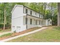 Side view of a two-story white brick home with a convenient two-car garage and a well-maintained lawn at 418 Mockingbird, Smyrna, GA 30082