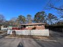 Quaint brick home with a covered porch and a picket fence, exuding curb appeal at 8118 Sw Collier Sw St, Covington, GA 30014
