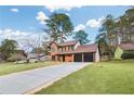Captivating home with a large, well-manicured lawn and long driveway leading to a three-car garage at 8914 Gardener Dr, Jonesboro, GA 30238