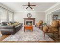 Cozy living room with a fireplace, hardwood floors, and an abundance of natural light at 3267 Standing Peachtree Nw Trl, Kennesaw, GA 30152