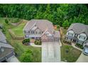 Expansive aerial view of a beautiful home with lush green lawn, mature trees, and a three car garage at 4240 Summer Breeze Way, Buford, GA 30518