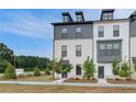 Elegant townhouse complex showcasing a mix of brick and siding, framed by lush trees and manicured landscaping at 533 Rubato Knl, Mcdonough, GA 30253