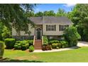 View of the front yard and home featuring mature trees, manicured shrubs, and inviting entrance at 90 Cypress Dr, Covington, GA 30016