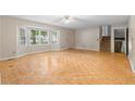 View of living room with parquet floors, fan, window, stairs and exterior door at 35 Pawn Dr, Carrollton, GA 30116