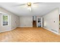 View of living room with parquet floors, fan, window, stairs and exterior door at 35 Pawn Dr, Carrollton, GA 30116