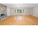 Spacious living room featuring natural light, beautiful parquet floors, and a stone fireplace at 35 Pawn Dr, Carrollton, GA 30116