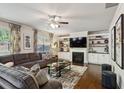 Cozy living room featuring a large sectional sofa, fireplace with built-in shelving, and hardwood floors at 6977 Demeter Dr, Atlanta, GA 30349