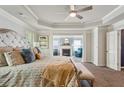 Bright main bedroom with tray ceilings, a fireplace, and a sitting area with large windows at 6977 Demeter Dr, Atlanta, GA 30349