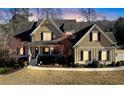 Charming two-story home featuring a welcoming front porch, gable roof, and manicured landscaping, set against a beautiful sky at 103 Old Avery Dr, Canton, GA 30115