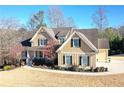 Inviting two-story home with a covered porch, manicured lawn, and detailed architectural features under a clear blue sky at 103 Old Avery Dr, Canton, GA 30115