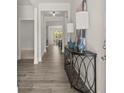 Inviting hallway showcasing wood floors and a decorative console table with lamps, leading to an open dining area at 64 Lakeview Pt, Dallas, GA 30157