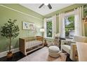 Cozy bedroom featuring a modern crib, soft natural lighting, and neutral decor at 1211 Mortimer Se Pl, Atlanta, GA 30317