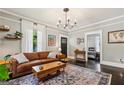 Bright living room featuring a leather sofa, decorative rug, and elegant chandelier at 1211 Mortimer Se Pl, Atlanta, GA 30317
