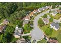 Aerial view of the property showcasing its location in a neighborhood with pond and lush greenery at 1316 Wind Chime Ct, Lawrenceville, GA 30045