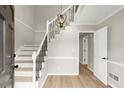 Bright foyer showcasing a staircase with modern iron railings and wood flooring at 5427 Fieldgreen Dr, Stone Mountain, GA 30088