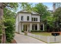 Charming two-story home with white siding, black trim, manicured landscaping, and a welcoming front porch at 357 Mell Ave, Atlanta, GA 30307