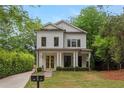 Charming two-story home with white siding, black trim, manicured landscaping, and a welcoming front porch at 357 Mell Ave, Atlanta, GA 30307