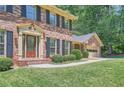 Beautiful brick home with well-maintained lawn and a two-car garage, nestled among mature trees at 3592 Midvale Cv, Tucker, GA 30084
