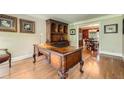 Office featuring hardwood floors, ornate desk, hutch and views into the dining room at 3592 Midvale Cv, Tucker, GA 30084
