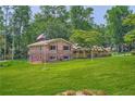 Two-story home featuring brick and siding, an American flag, and a green lawn at 5401 Smoke Rise Dr, Smoke Rise, GA 30087