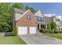 View of the home's brick and siding exterior, showcasing the two-car garage and landscaping at 2365 Valley Mill Dr, Buford, GA 30519