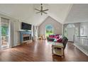 Spacious living room featuring high ceilings, a stone fireplace, large windows, and hardwood flooring for an elegant look at 6645 N Glen Dr, Cumming, GA 30028
