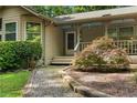 Inviting front porch with a decorative tree, stone edging, and a covered entryway at 1920 Jett Ridge Rd, Cumming, GA 30041
