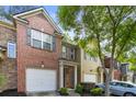 Beautiful townhouse featuring brick facade, attached garage, and manicured landscaping at 3379 Thornbridge Dr, Powder Springs, GA 30127