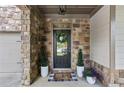 Elegant front door with stone surround and a decorative wreath at 4779 Bogan Meadows Dr, Buford, GA 30519