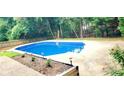 Sparkling in-ground pool with concrete surround and wooden perimeter fence at 6005 Pattingham Dr, Roswell, GA 30075