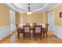 Bright dining room features hardwood floors, elegant lighting, and ample seating for six at 1085 Highland Crest Ct, Mableton, GA 30126