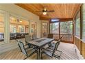 Relaxing screened-in porch with a dining table, fan, and wood ceiling at 1085 Highland Crest Ct, Mableton, GA 30126