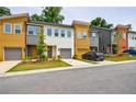 Charming townhomes with colorful exteriors, attached garages, and landscaped front yards along a quiet street at 1624 Gunnin Nw Trce, Atlanta, GA 30318