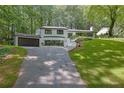 Charming two-story home with landscaped yard, dark trim, and an attached garage at 2858 Mornington Nw Dr, Atlanta, GA 30327