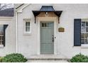 Close up of the light gray front door with black awning on a white brick home at 332 Shadowmoor Dr, Decatur, GA 30030
