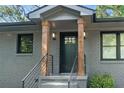 Inviting front porch with black railings, wood pillars, and stylish lighting at 1643 Flintwood Se Dr, Atlanta, GA 30316