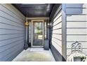 Stylish covered entryway with gray siding, a glass front door with sidelights, and decorative outdoor accents at 2190 Ashley Crossing Ct, Lawrenceville, GA 30043
