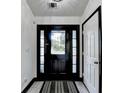 Well-lit entryway featuring a decorative front door with sidelights, contrasting trim, and a stylish rug at 2190 Ashley Crossing Ct, Lawrenceville, GA 30043